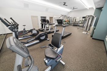 a room filled with lots of different types of exercise equipment at Montgomery Place Apartments, Montgomery